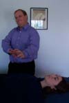Reiki practitioner sweeps extra energy toward the client's feet.